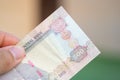 Hand holding Currency of the United Arab Emirates UAE - Close up of a purple five hundred Dirham note  on a blurred background Royalty Free Stock Photo