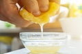 hand holding a cut slice of lemon and squeeze the fresh juice to the bowls Royalty Free Stock Photo