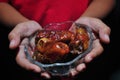 Hand holding date fruit or kurma in the bowl