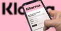 Hand holding a device with the Klarna mobile app on the screen