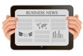 Hand holding digital tablet pc with business news.