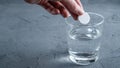 An effervescent aspirin tablet is thrown into a glass of water. Background with space for text Royalty Free Stock Photo