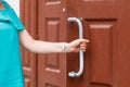 Hand holding door knob, opening door slightly, selective focus Royalty Free Stock Photo