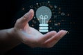 hand holding drawing virtual lightbulb on dark blue background for creative and smart thinking idea concept. Royalty Free Stock Photo