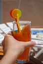 Hand holding drink in front of the pool