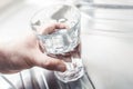 Hand Holding A Drinking Glass Filled Up With Water On A Kitchen Sink Royalty Free Stock Photo