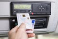 Hand holding a driver digital card and Europian driving licence infront of a digital tachograph. No personal data Royalty Free Stock Photo