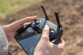 Hand holding drone remote controler to operate flying drone