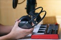 Hand holding earphone near sound mixing console board. Equipment for the music studio Royalty Free Stock Photo