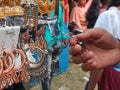 Hand holding earrings or jhumka in a mela, traditional earring close up