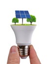 Hand holding eco LED light bulb with solar panel isolated on white background. Royalty Free Stock Photo