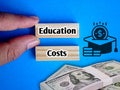 Hand holding Education Costs text at Wooden blocks, icon and money. Education and finance concept Royalty Free Stock Photo