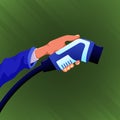 Hand holding electric car charger connector isolated on green background. Royalty Free Stock Photo