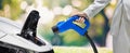 Hand holding Electric car charger. Electric Vehicle EV Charging station on blurred nature with soft light background. Air pollutio Royalty Free Stock Photo