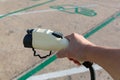 Hand holding Electric car charger. Electric Vehicle EV Charging station & Charger. Human hand is holding Electric Car Charging con Royalty Free Stock Photo