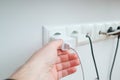 Hand holding Electric plug put on multiple socket. Electrical equipment, electrical wires and power strips in the house. Earth Royalty Free Stock Photo