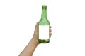 Hand holding an empty green glass bottle with a text space isolated on a white background. Royalty Free Stock Photo