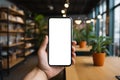 Hand holding empty screen of smartphone in office co working space, Generate with AI. Royalty Free Stock Photo