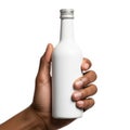 A hand holding an empty white bottle with a silver cap against a white background Royalty Free Stock Photo