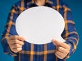 Hand holding of an empty white speech bubble against a blue background Royalty Free Stock Photo