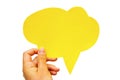 Hand holding an empty yellow hand-cuted paper speech bubble on white background. Isolated.