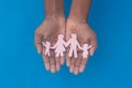 Hand holding family figure cutout top view. World health day Protection against domestic violence, healthcare and medical Royalty Free Stock Photo