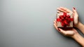 Hand holding a festive holiday gift against a solid silver background Royalty Free Stock Photo