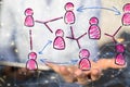 Hand holding floating pink icons of people - a structure of world economy, communication, network