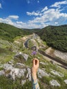 Hand Holding Flower on River Canyon Background