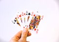 Hand holding a flush of Jack and Queen cards of poker over a white background Royalty Free Stock Photo