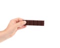 Hand holding foiled dark chocolate bar.