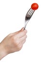 Hand holding fork with one fresh red cherry tomato Royalty Free Stock Photo