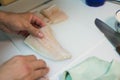 hand holding a fresh piece of hake for cooking