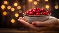 Hand holding fresh tart cranberries, with copy space, on blurred background for text placement