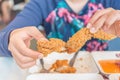 Hand holding Fried chicken and eating in the restaurant Royalty Free Stock Photo