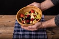 Hand holding a fruit salad bowl ready to eat very healthy and a finger pointing