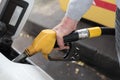 Hand holding fuel pump nozzle and refilling car Royalty Free Stock Photo