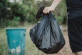 Hand holding a garbage bag and are being dropped into the trash