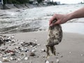 Hand holding garbage at dirty beach,ecological problem