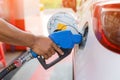 Hand holding gas nozzle with one last drop. A man holding a gasoline nozzle. Royalty Free Stock Photo