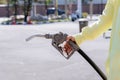 Hand holding gas nozzle with one last drop. A man holding a gasoline nozzle. Royalty Free Stock Photo