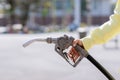 Hand holding gas nozzle with one last drop. A man holding a green gasoline nozzle. Royalty Free Stock Photo