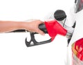 Hand holding gasoline nozzle filling up a car isolated on white