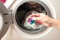 Hand holding gel caps for washing machine. Household laundry equipment. Spring clothes cleaning Royalty Free Stock Photo