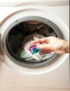 Hand holding gel caps for washing machine. Household laundry equipment. Spring clothes cleaning Royalty Free Stock Photo