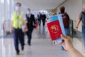 Hand holding generic passport, face mask,, boarding pass in airport Royalty Free Stock Photo