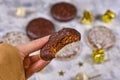 Hand holding German round gingerbread called `Lebkuchen` with chocolate glazing