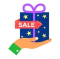 Hand holding gift box with sale tag, concept of discounted shopping. Present with stars and ribbon, shopping promotion