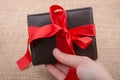 Hand holding a wallet wrapped with ribbon