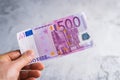 Hand holding and giving five hundred euro banknotes. Money in man hands on gray background Royalty Free Stock Photo